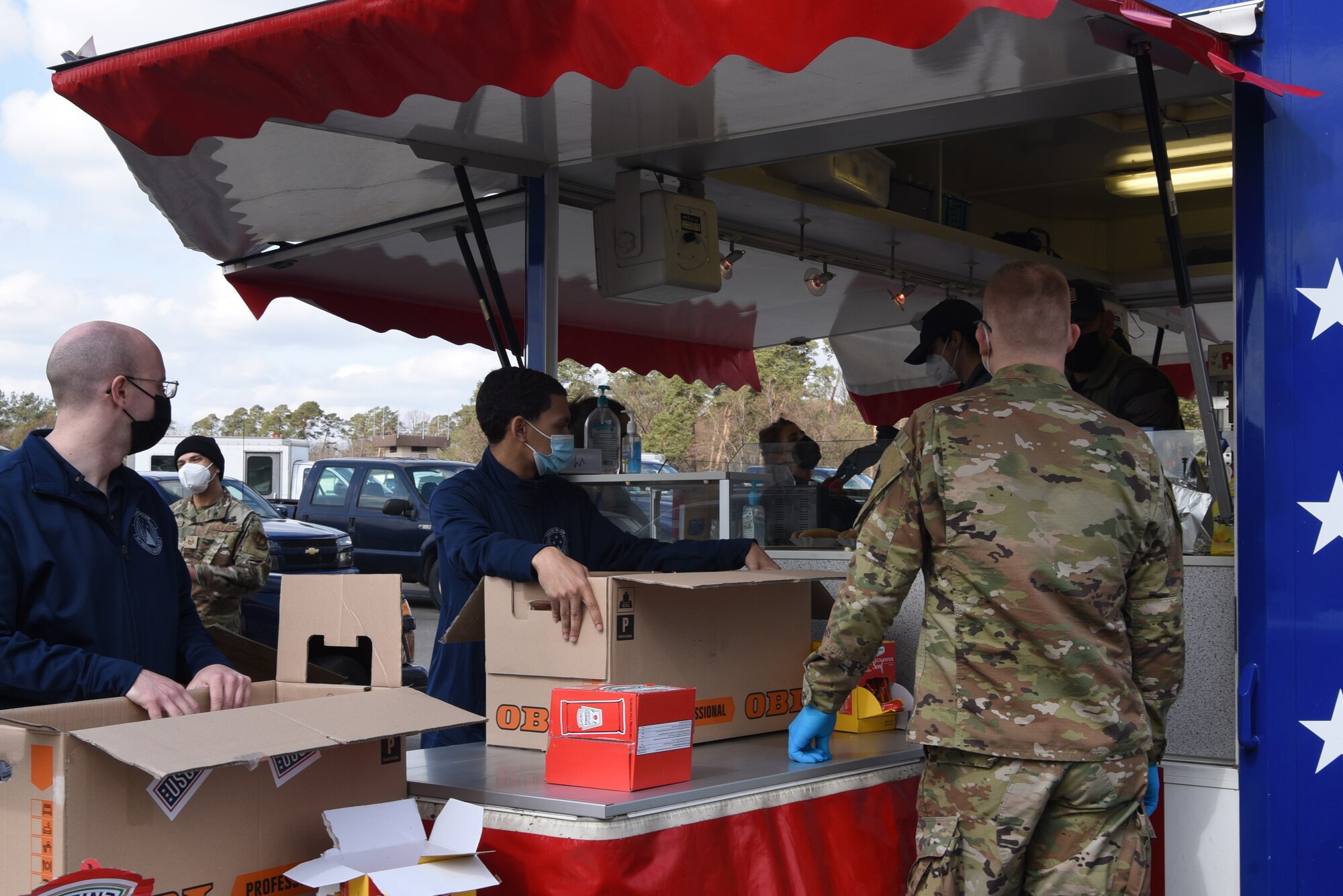 U.S. Air Force Airman 1st Class Luke Langbehn, 86th Vehicle Readiness Squadron ground transportation, right, waits to prepare boxes of lunches for his fellow Airmen within the 86th Logistics Readiness Group.