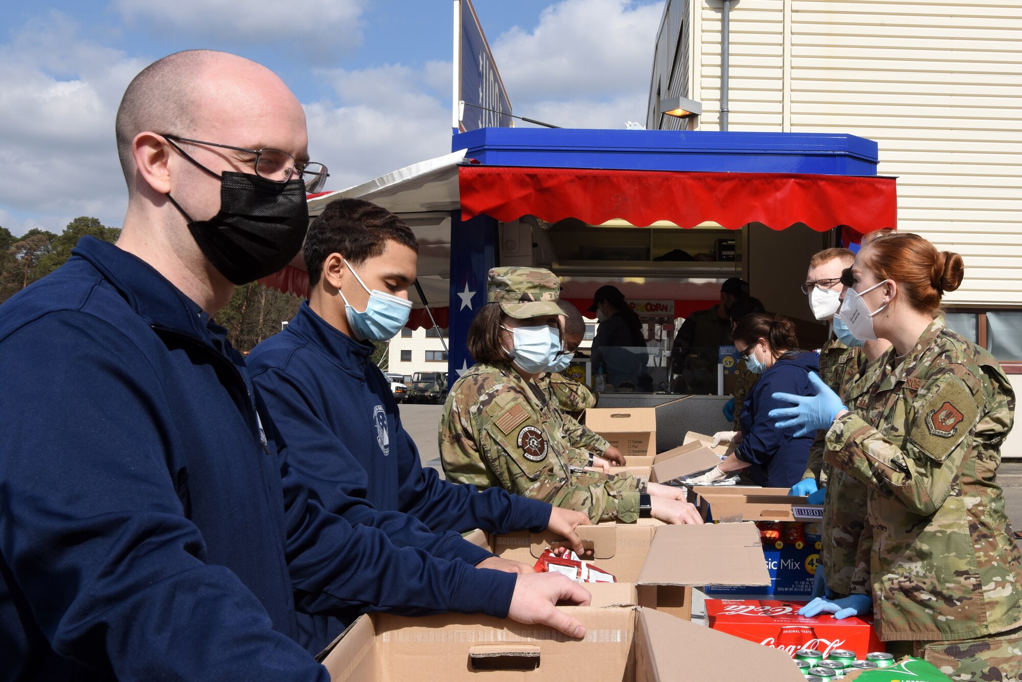 U.S. Air Force Airmen assigned to the 86th Vehicle Readiness Squadron, right, fill boxes with lunches for fellow 86th Logistics Readiness Group Airmen on the VRS compound.