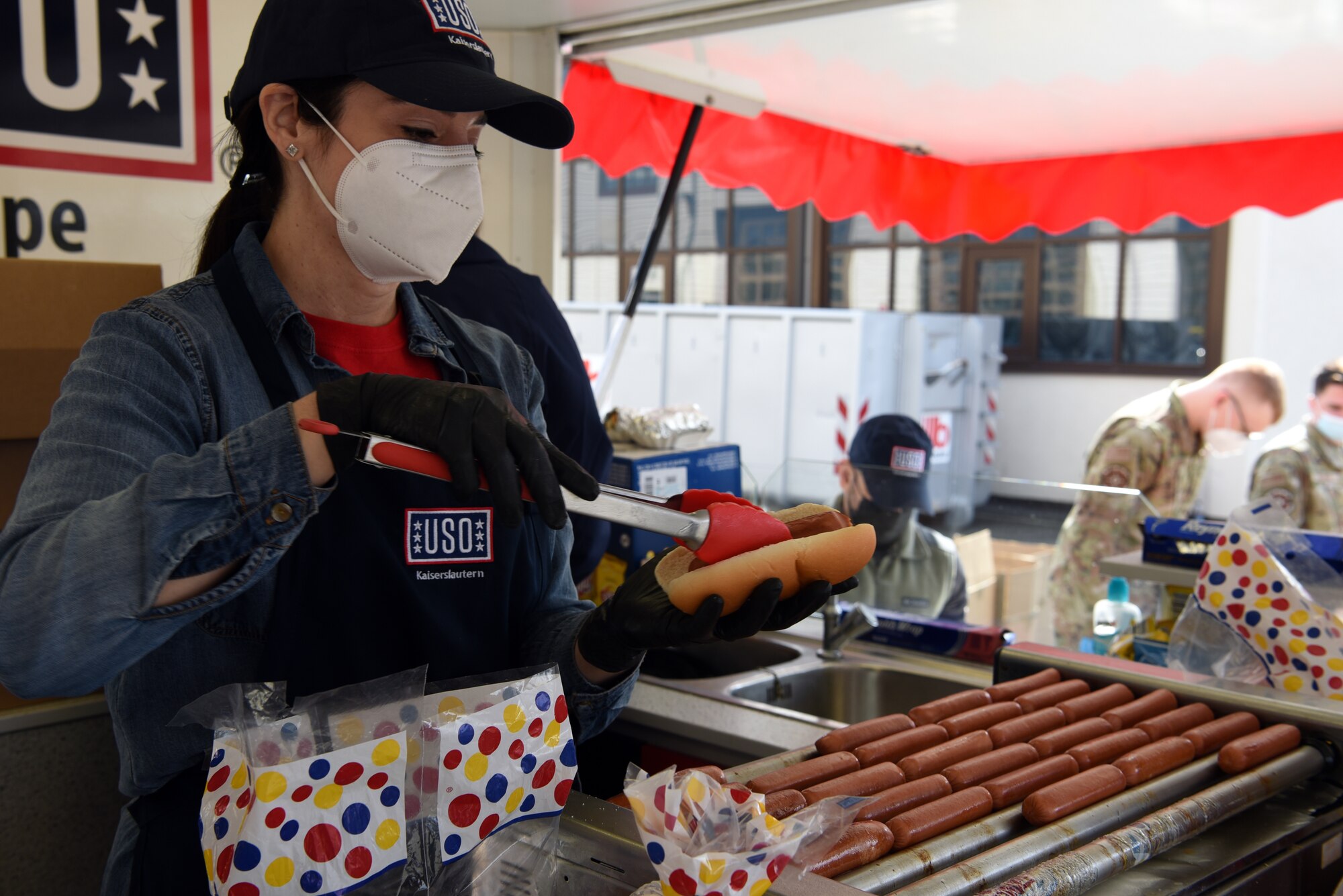 Leslie Champion, USO volunteer and U.S. Air Force spouse, prepares hot dogs for members of the 86th Logistics Readiness Group.