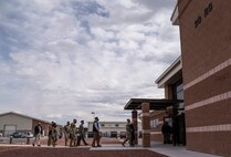 Acting Secretary of the Air Force Roth is escorted into a building.