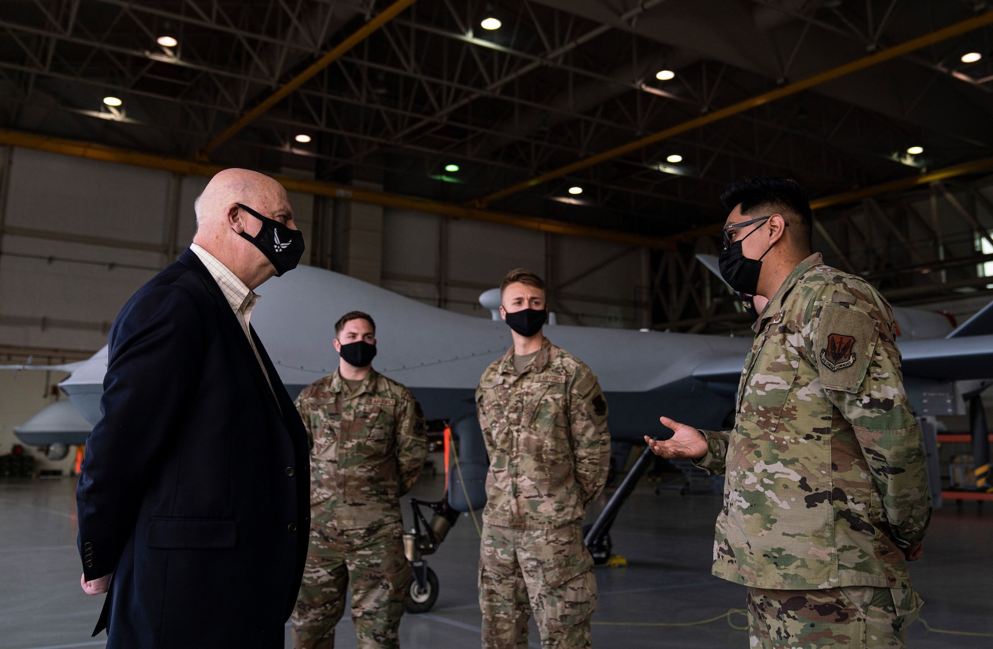 Acting Secretary of the Air Force John Roth interacts with Airmen by an MQ-9 Reaper.