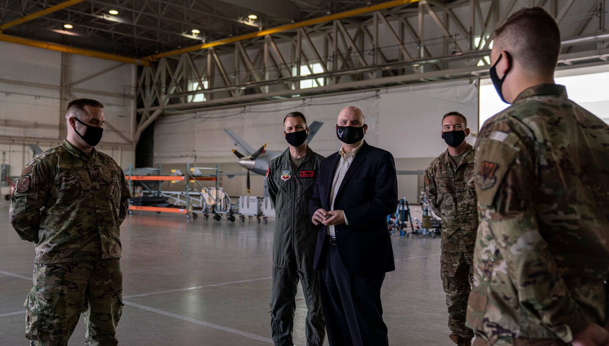Acting Secretary of the Air Force John Roth interacts with Airmen in a hangar.