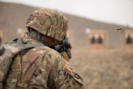 a soldier shoots a rifle at a target