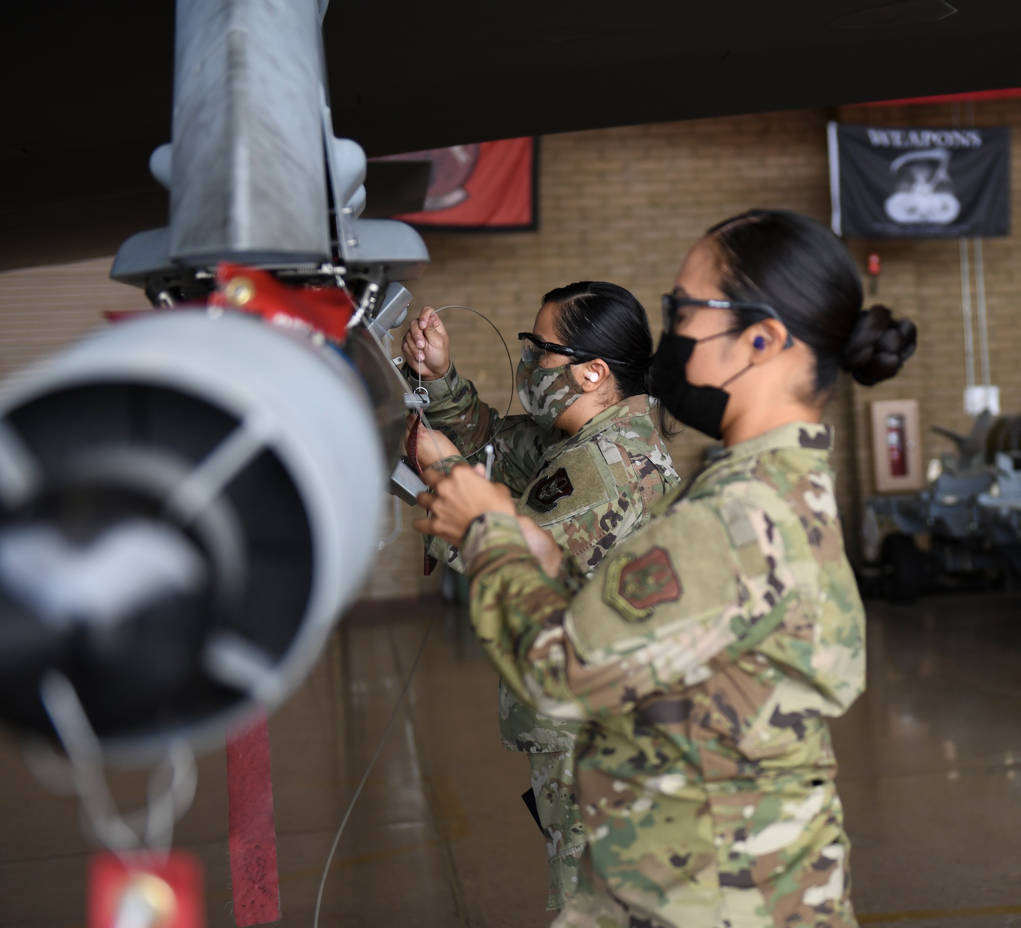 Tech. Sgt. Joyce Osornio-Magaña, front, 944th Fighter Wing weapons load technician, and Senior Airman Jocelyn Zavala, 62nd Aircraft Maintenance Unit weapons load technician, participate in a Women of Weapons Exhibition Load March 25, 2021, at Luke Air Force Base, Arizona. The exhibition load involved three teams made up of all women from different backgrounds, units, and ranks, honoring female maintainers for Women’s History Month. Diversity allows the Air Force to capitalize on all available talent by enabling a culture of inclusion. (U.S. Air Force photo by Staff Sgt. Amber Carter)
