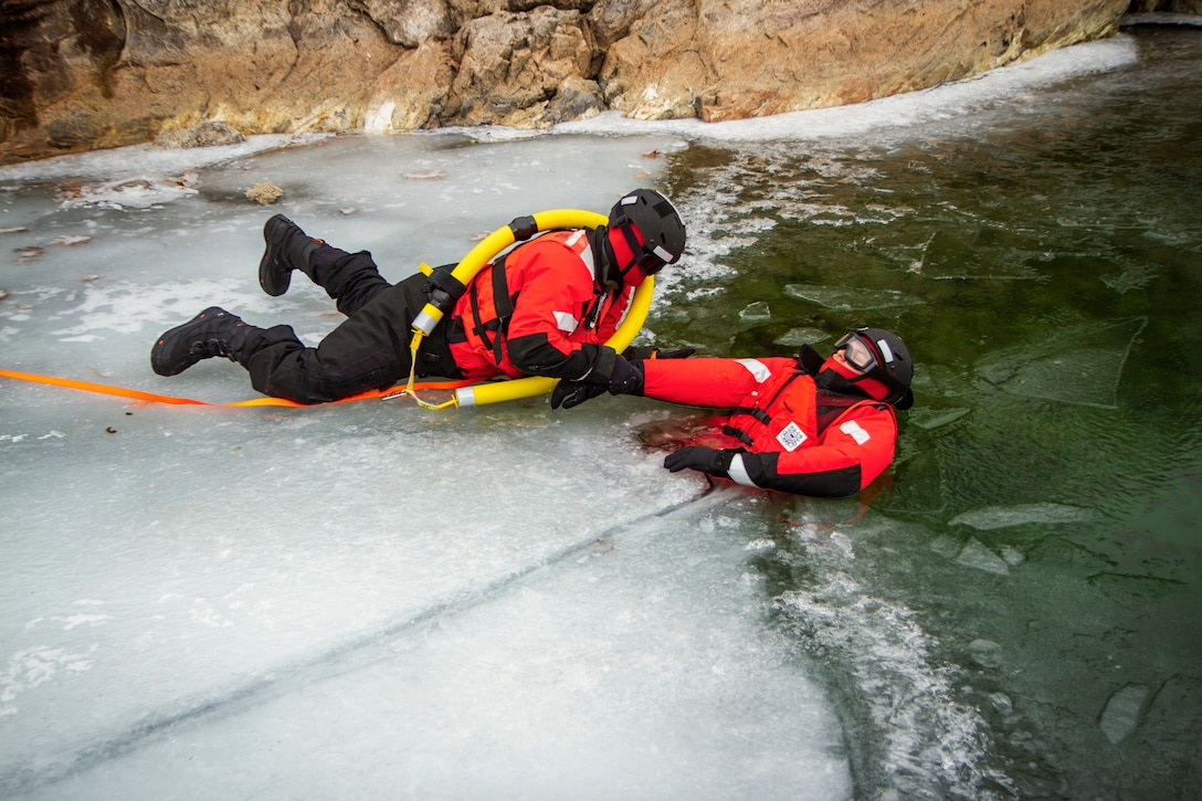 A Coast Guardsman rescues a fellow guardsman from icy water during training.