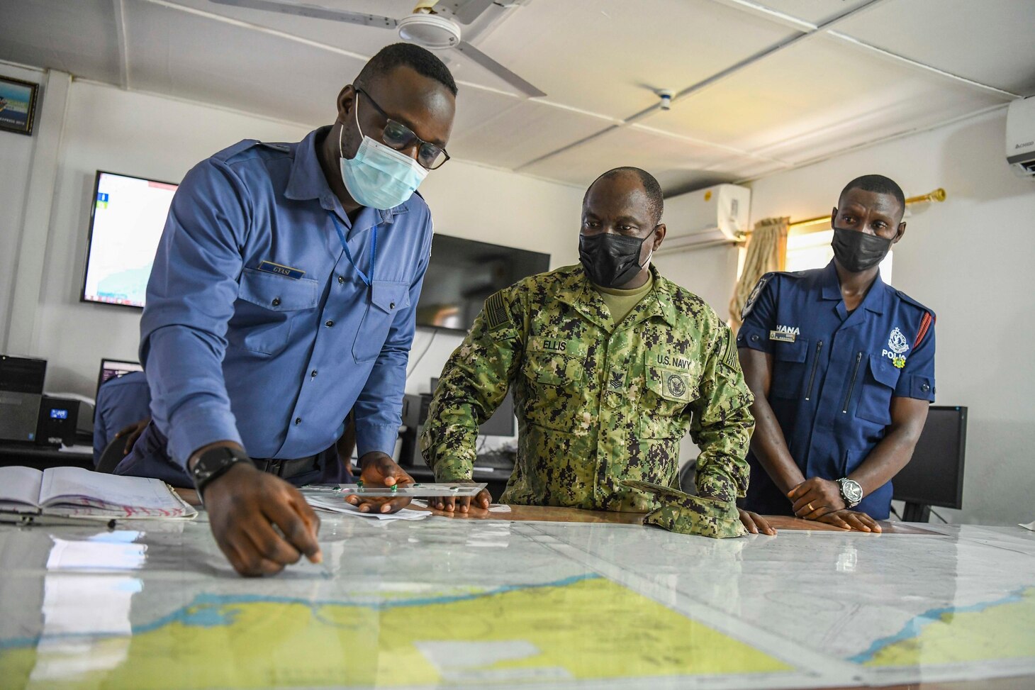 Information Systems Technician 1st Class Samuel Ellis and Sailors in the Ghanaian Navy review a map in a maritime operation center during Exercise Obangame Express 2021, March 22, 2021.