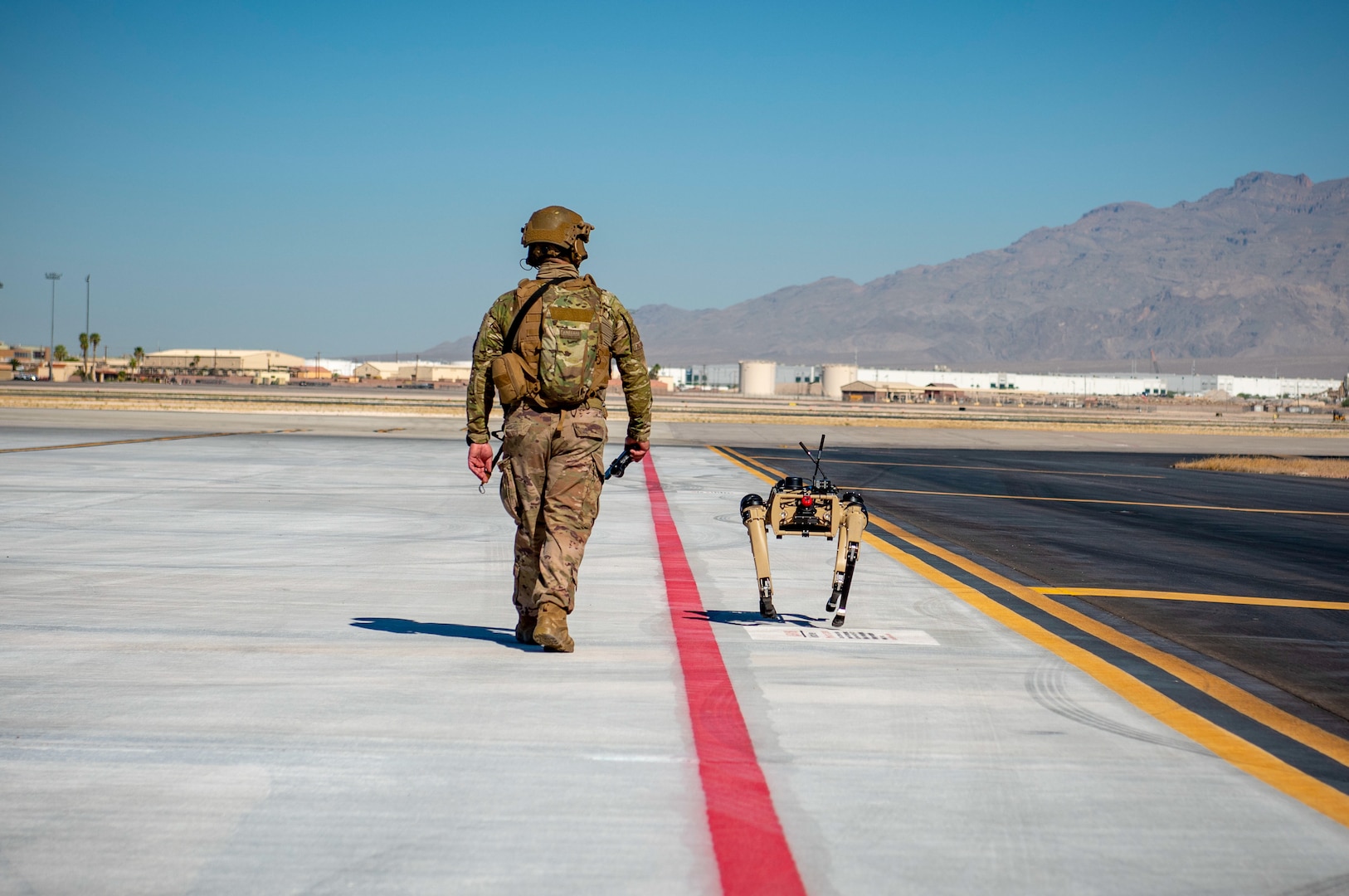 Airman with 321st Contingency Response Squadron security team patrols with Ghost Robotics Vision 60 prototype at simulated austere base during Advanced Battle Management System exercise on Nellis Air Force Base, Nevada, September 3, 2020 (U.S. Air Force/Zachary Rufus)