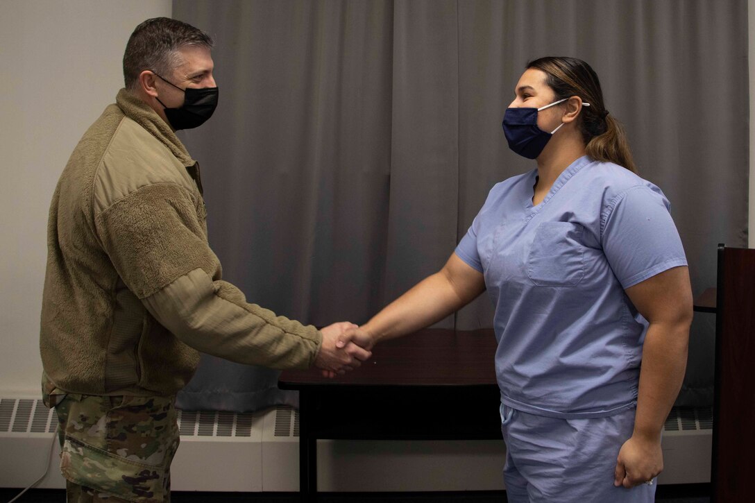 Maj. Gen. Torrence Saxe, adjutant general of the Alaska National Guard, left, awards Staff Sgt. Jessica Hooker a coin during a visit to Eielson Air Force Base, Alaska, March 23, 2021. (U.S. Army National Guard photo by Victoria Granado)