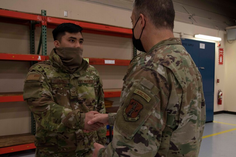 Maj. Gen. Torrence Saxe, adjutant general of the Alaska National Guard, right, awards Staff Sgt. Austin Cardines a coin during a visit to Eielson Air Force Base, Alaska, March 23, 2021. (U.S. Army National Guard photo by Victoria Granado)