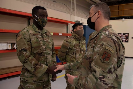 Maj. Gen. Torrence Saxe, adjutant general of the Alaska National Guard, right, awards Staff Sgt. Salem Dogbe a coin during a visit to Eielson Air Force Base, Alaska, March 23, 2021. (U.S. Army National Guard photo by Victoria Granado)