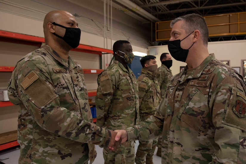 Maj. Gen. Torrence Saxe, adjutant general of the Alaska National Guard, right, awards Tech Sgt. Steven Woodson a coin during a visit to Eielson Air Force Base, Alaska, March 23, 2021. (U.S. Army National Guard photo by Victoria Granado)