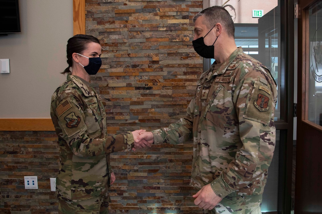 Maj. Gen. Torrence Saxe, adjutant general of the Alaska National Guard, right, awards Master Sgt. Jennifer Pottinger a coin during a visit to Eielson Airforce Base, Alaska, March 23, 2021. (U.S. Army National Guard photo by Victoria Granado)