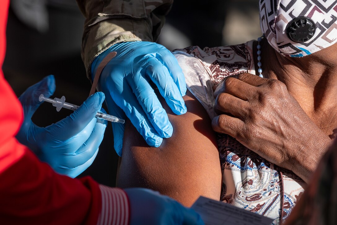 A U.S. Army combat medic administers a COVID-19 vaccine.