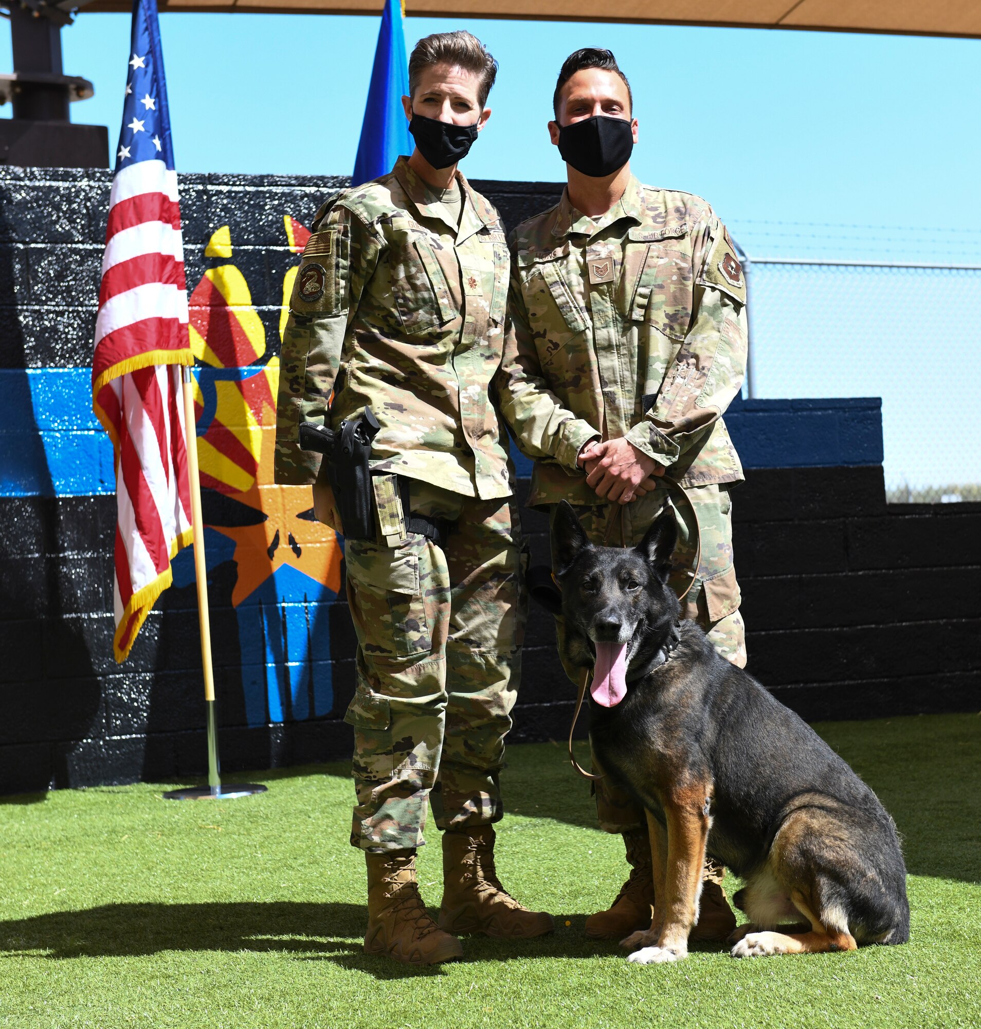 Maj. Kimberly Guest, left, 56th Security Forces Squadron commander, and Tech. Sgt. Zackery Hons, 56th SFS military working dog handler, honor Rango, 56th SFS MWD, as he retires March 19, 2021 at Luke Air Force Base, Arizona. Rango, an 8-year old Czech German Shepherd, leaves behind the legacy of taking first place at the 2019 Desert Dog Trials for narcotic detection, beating 70 other K-9 teams, and will retire into the care of his former handler. As the Air Force prepares to retire a MWD, the dog’s handler can request to adopt the dog enabling it to live the remainder of its life as a family member. Boss and Rango will retire and live at home with their respective handler. (U.S. Air Force photo by Staff Sgt. Amber Carter)