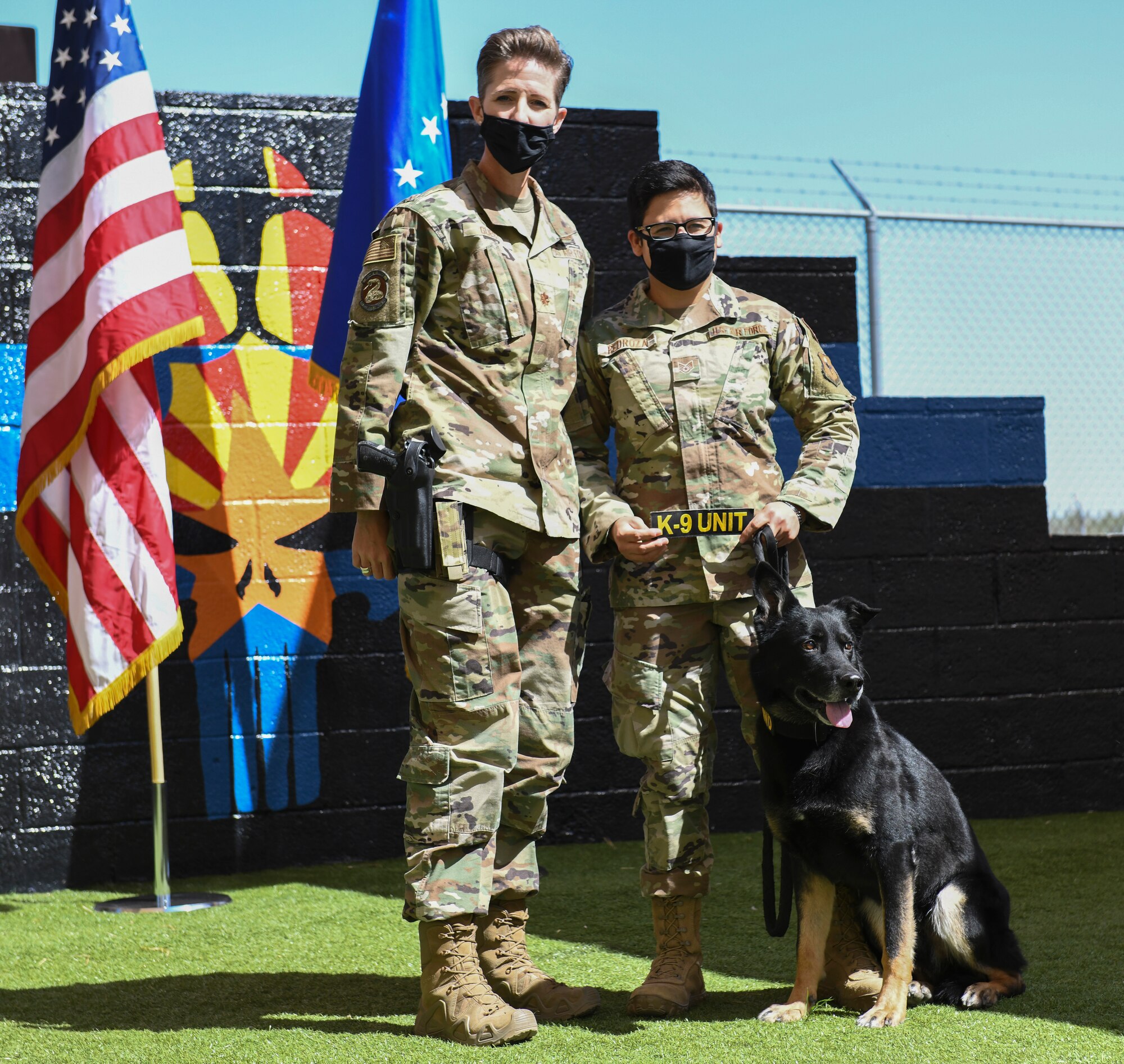 Maj. Kimberly Guest, left, 56th Security Forces Squadron commander, and Staff Sgt. Elizabeth Pedroza, 56th SFS military working dog handler, honor Boss, 56th SFS military working dog, as he retires March 19, 2021 at Luke Air Force Base, Arizona. Boss, who was recently diagnosed with cancer, served in the Air Force for seven years, completing two deployments to Al Dhafra Air Base, United Arab Emirates, and will live with Pedroza, his handler. As the Air Force prepares to retire a MWD, the dog’s handler can request to adopt the dog enabling it to live the remainder of its life as a family member. Boss and Rango will retire and live at home with their respective handler. (U.S. Air Force photo by Staff Sgt. Amber Carter)