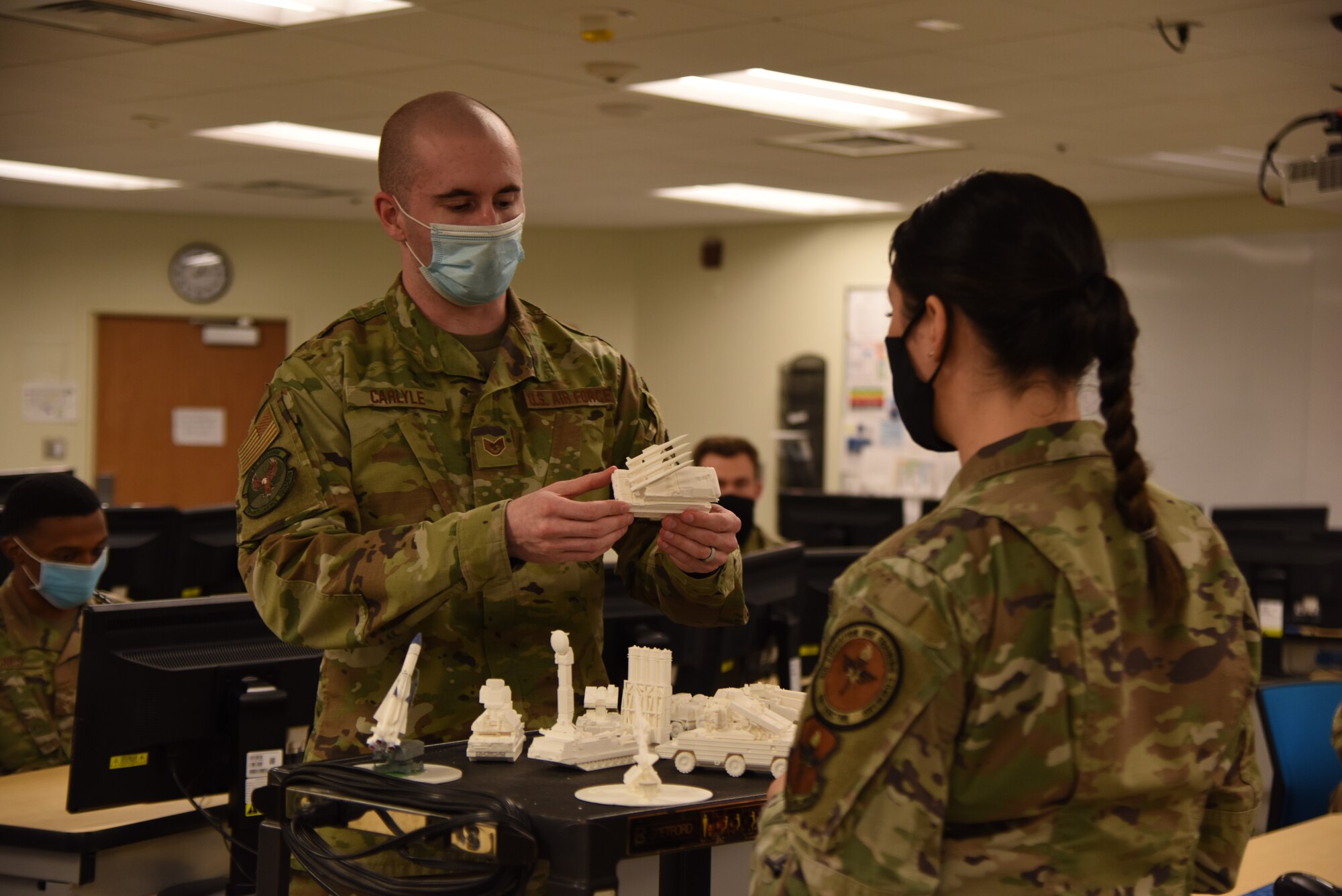 U.S. Air Force Staff Sgt. Austin Carlyle, 315th Training Squadron student, explains the piece of equipment the three-dimensional model represents to Tech. Sgt. Mollie Whitley, 315th TRS instructor. The three-dimensional models allow the students to obtain a more advanced understanding of the equipment and allows them to see the equipment from any angle. (U.S. Air Force photo by Senior Airman Ashley Thrash)