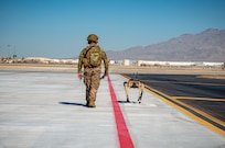 Airman with 321st Contingency Response Squadron security team patrols with Ghost Robotics Vision 60 prototype at simulated austere base during Advanced Battle Management System exercise on Nellis Air Force Base, Nevada, September 3, 2020 (U.S. Air Force/Zachary Rufus)