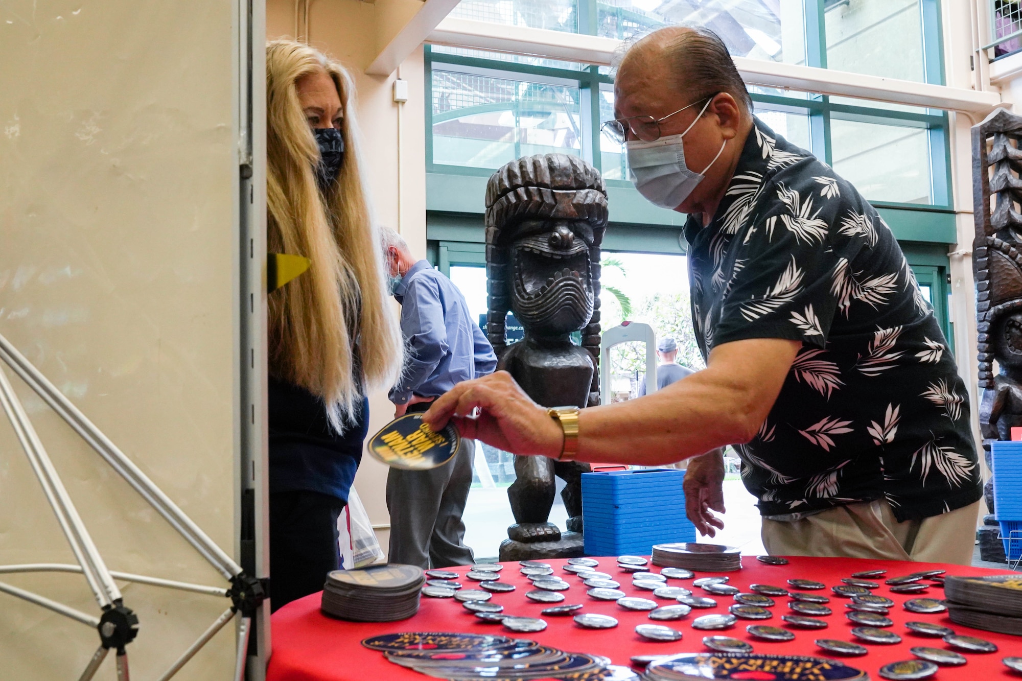 Yvonne Palmieri, Hickam Base Exchange store manager, assists Kenji Tanaka, retired U.S. Army veteran, during a pinning ceremony in honor of Vietnam War Veterans Day at Joint Base Pearl Harbor-Hickam, Hawaii, March 29, 2021. In 2017, President Donald Trump declared National Vietnam War Veterans Day because on this day in 1973 U.S. combat troops departed the Republic of Vietnam. (U.S. Air Force photo by Airman 1st Class Makensie Cooper)