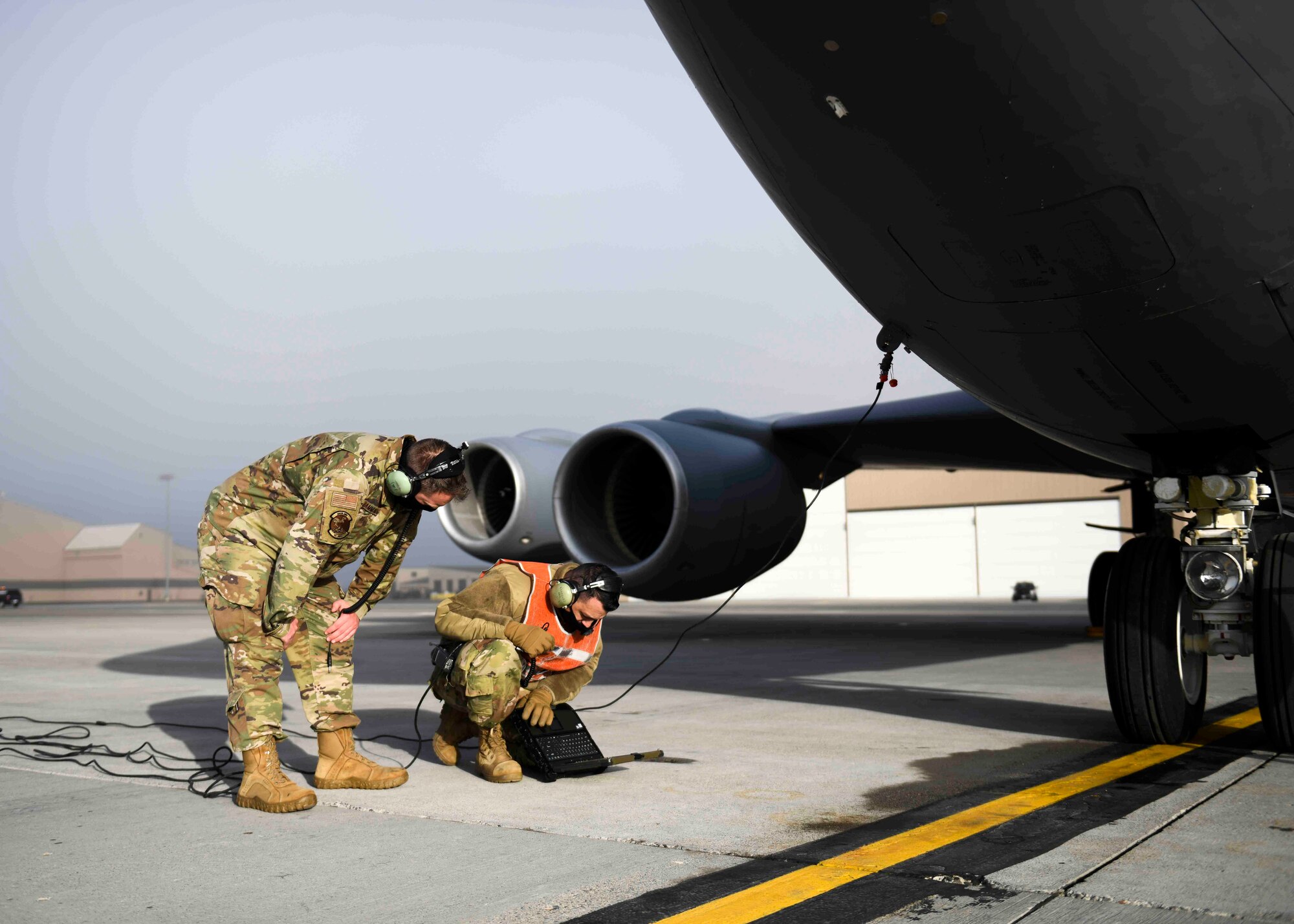 Airmen from the 92nd Maintenance Squadron read through a technical order prior to performing hot refueling on a KC-135 Stratotanker on Fairchild Air Force Base, Washington, March 25, 2021. Hot pit refueling requires cohesiveness between several key players on base, including but not limited to the 92nd Logistics Readiness Squadron, the 92nd MXS, and several air refueling squadrons. (U.S. Air Force photo by Airman 1st Class Kiaundra Miller)