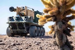 An autonomous vehicle drives across a desert floor.