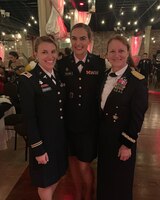 Three female officers stand in dress uniform