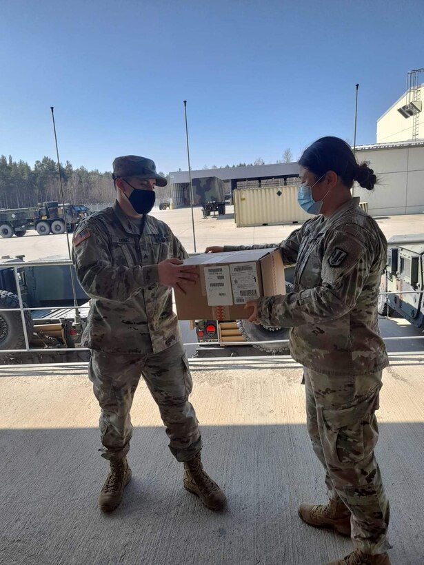 Two soldiers hold a box of Passover Seder kits.