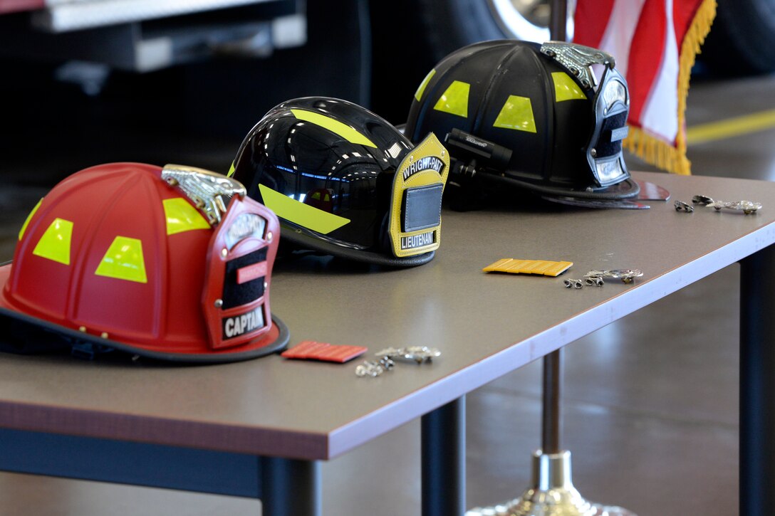 Air Force firefighters from the 788th Civil Engineer Squadron were promoted during a ceremony at Wright-Patterson Air Force Base, Ohio on Monday, March 29, 2021. New helmets, badges and rank from the left were for new firefighter Ryan Hartmann, Lt. Chad Engman, and Capt. James Hammond. (U.S. Air Force photo by Ty Greenlees)
