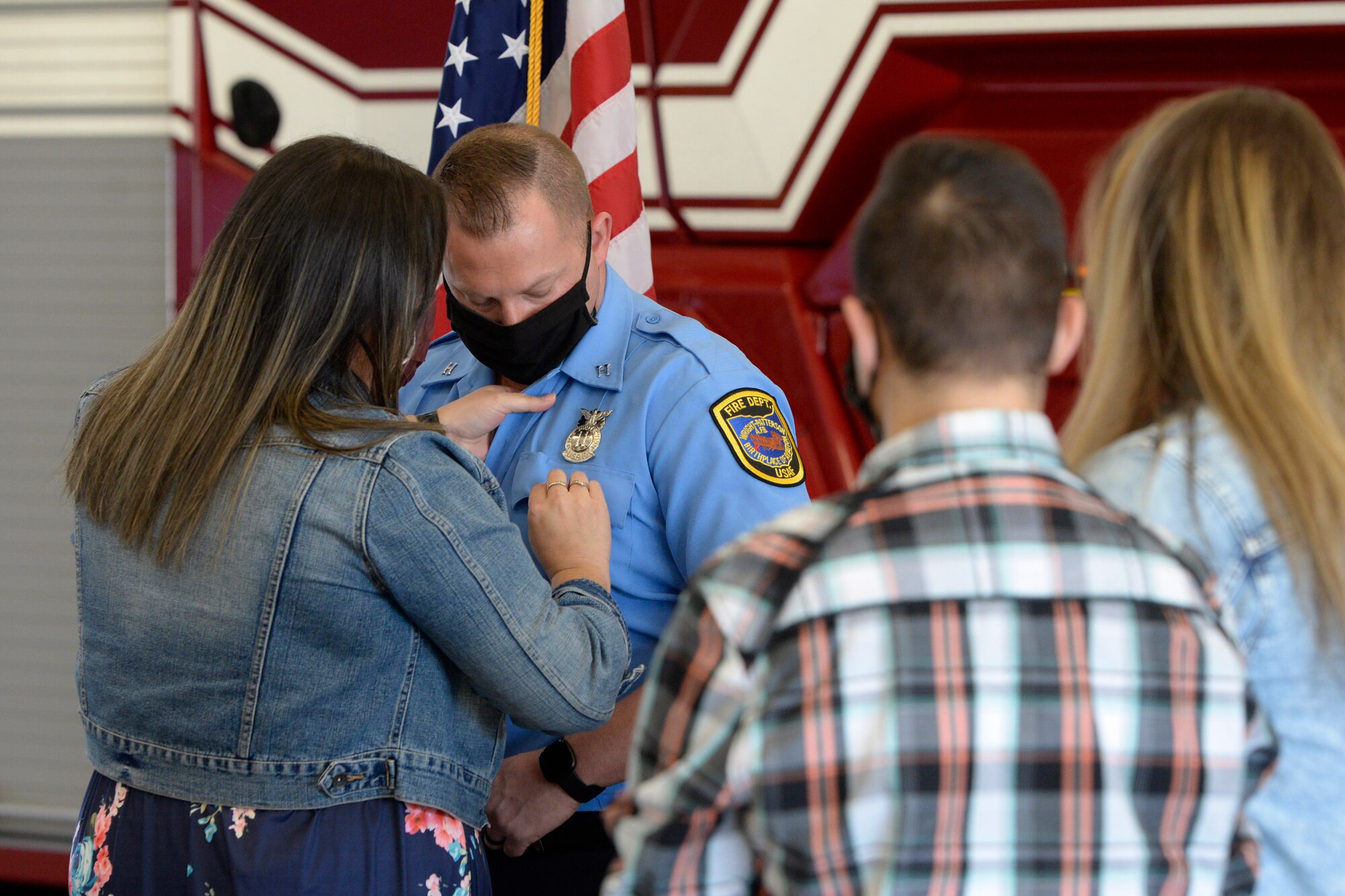 Air Force firefighter Capt. James Hammond with the 788th Civil Engineer Squadron, is pinned on by his wife, Ashlee, and children J.J. and Madison during a promotion ceremony at Wright-Patterson Air Force Base, Ohio on Monday, March 29, 2021.