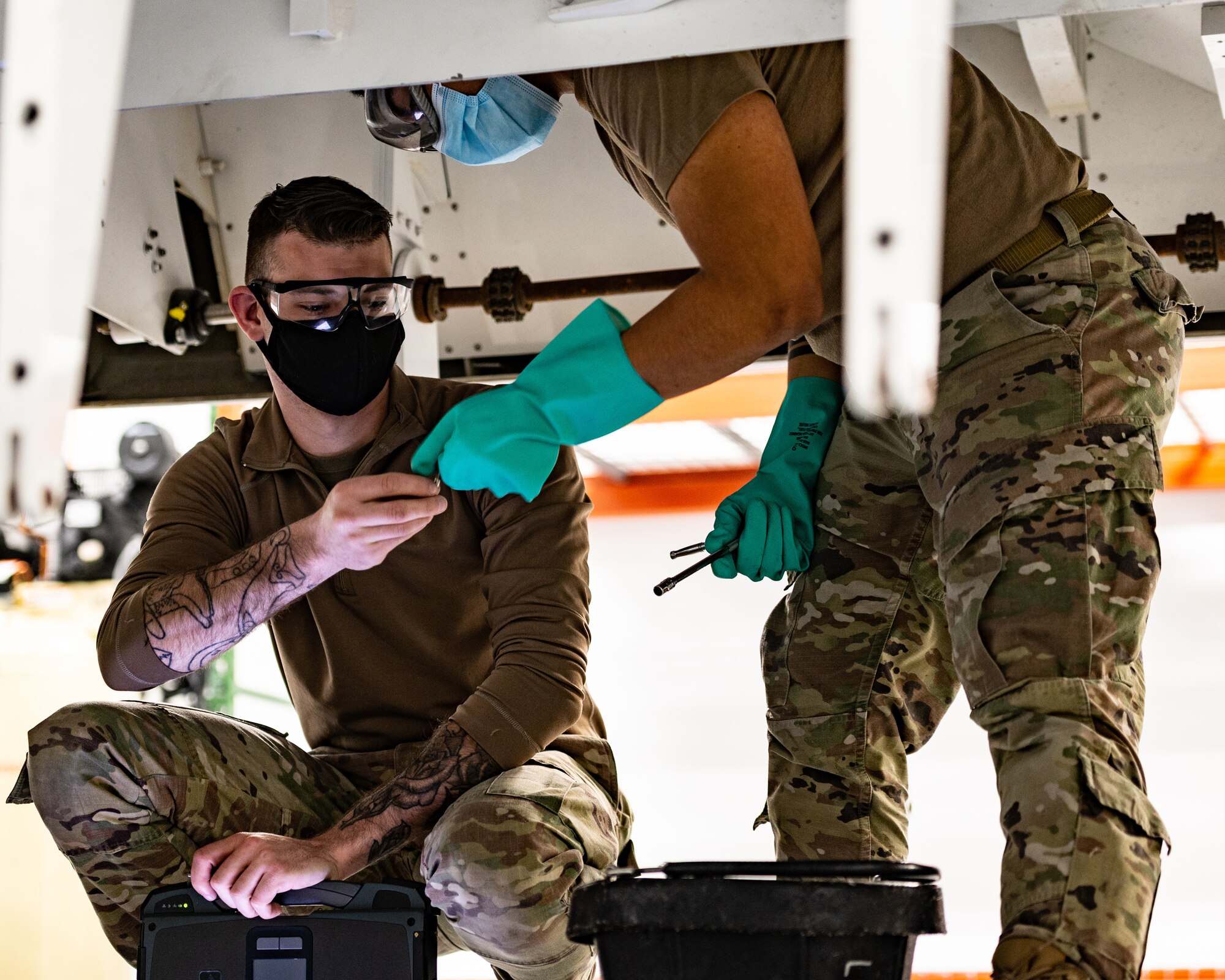 U.S. Air Force Senior Airman Efren Estrada and Airman 1st Class Brandon Wilson, 1st Maintenance Group fuels technicians, exchange tools for fuel tank installation during F-22 Raptor fuel system and On-Board Inert Gas Generating system training at Joint Base Langley-Eustis, Virginia, March 15, 2021.