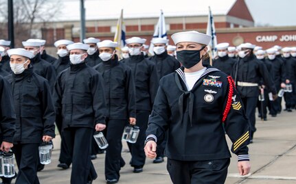 Petty Officer 1st Class Sarah Minnick, a recruit division commander, marches alongside her recruit division at Recruit Training Command. More than 40,000 recruits train annually at the Navy’s only boot camp. The command’s mission is to transform civilians into smartly disciplined, physically fit, basically trained Sailors who are ready for follow-on training and service to the fleet while instilling in them he highest standards of honor, courage, and commitment.