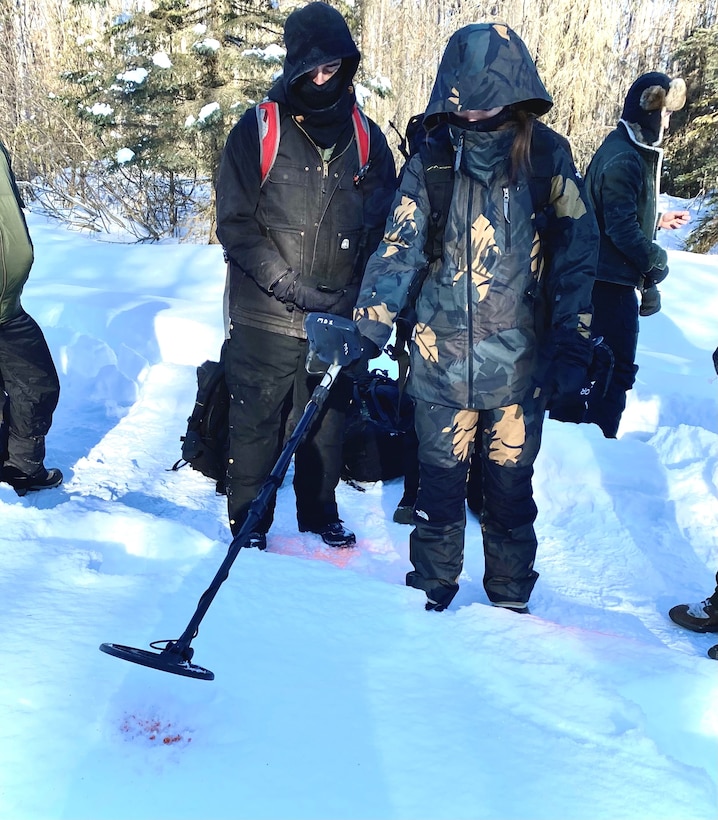 Staff Sgt. Jaimie Doney, 673rd Security Forces Squadron, and Special Agent Mike O’Hara, Office of Special Investigations, Detachment 631, use a metal detector to search for a bullet casing buried three feet in the snow. This was part of a snow-based exercise held at Joint Base Elmendorf-Richardson, Alaska, March 18-19, to test operational readiness in winter environments (U.S. Air Force photo by 1st Lt. Ashlyn K. Paulson).