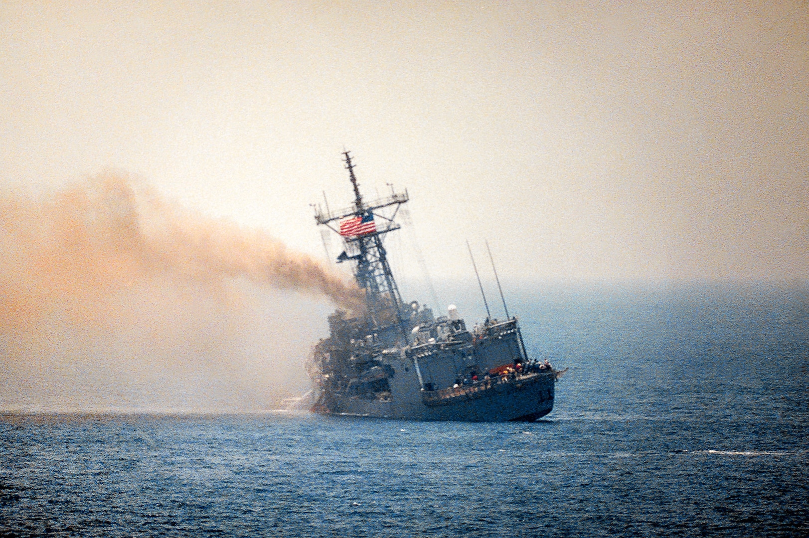 USS Stark listing to port after being struck by two Iraqi-launched Exocet missiles, Persian Gulf, May 17, 1987 (U.S. Navy)