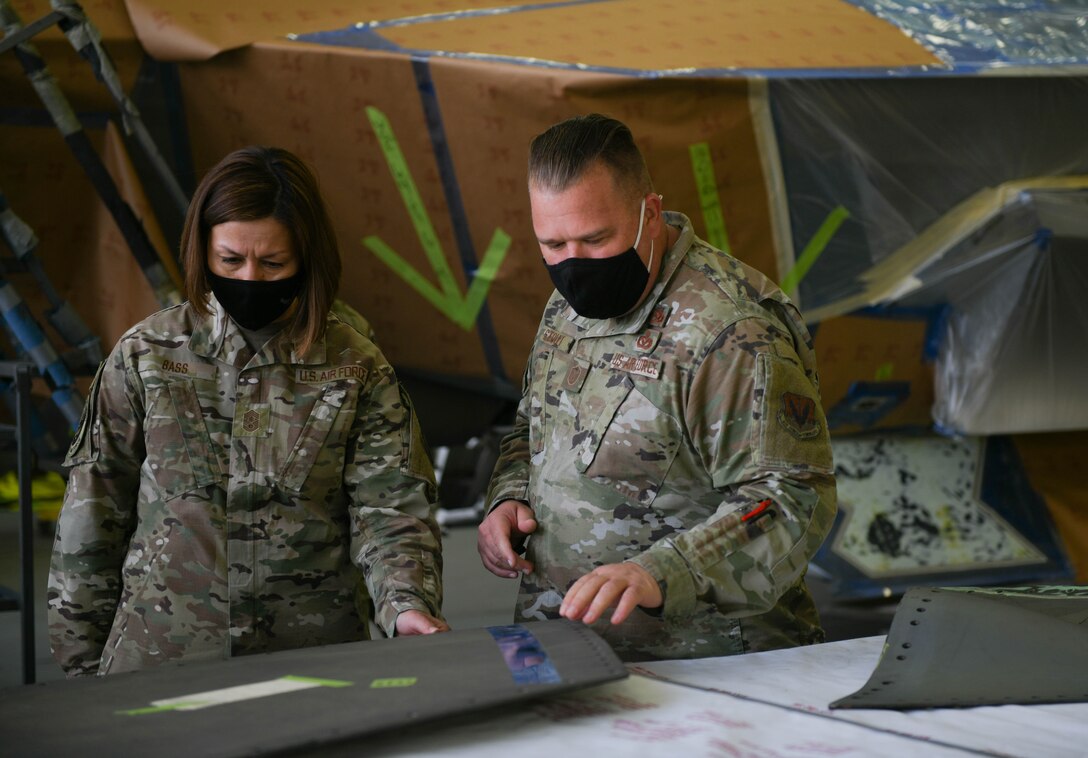Chief Bass talks with Master Sgt. Michael Stout as they look over part of an air craft