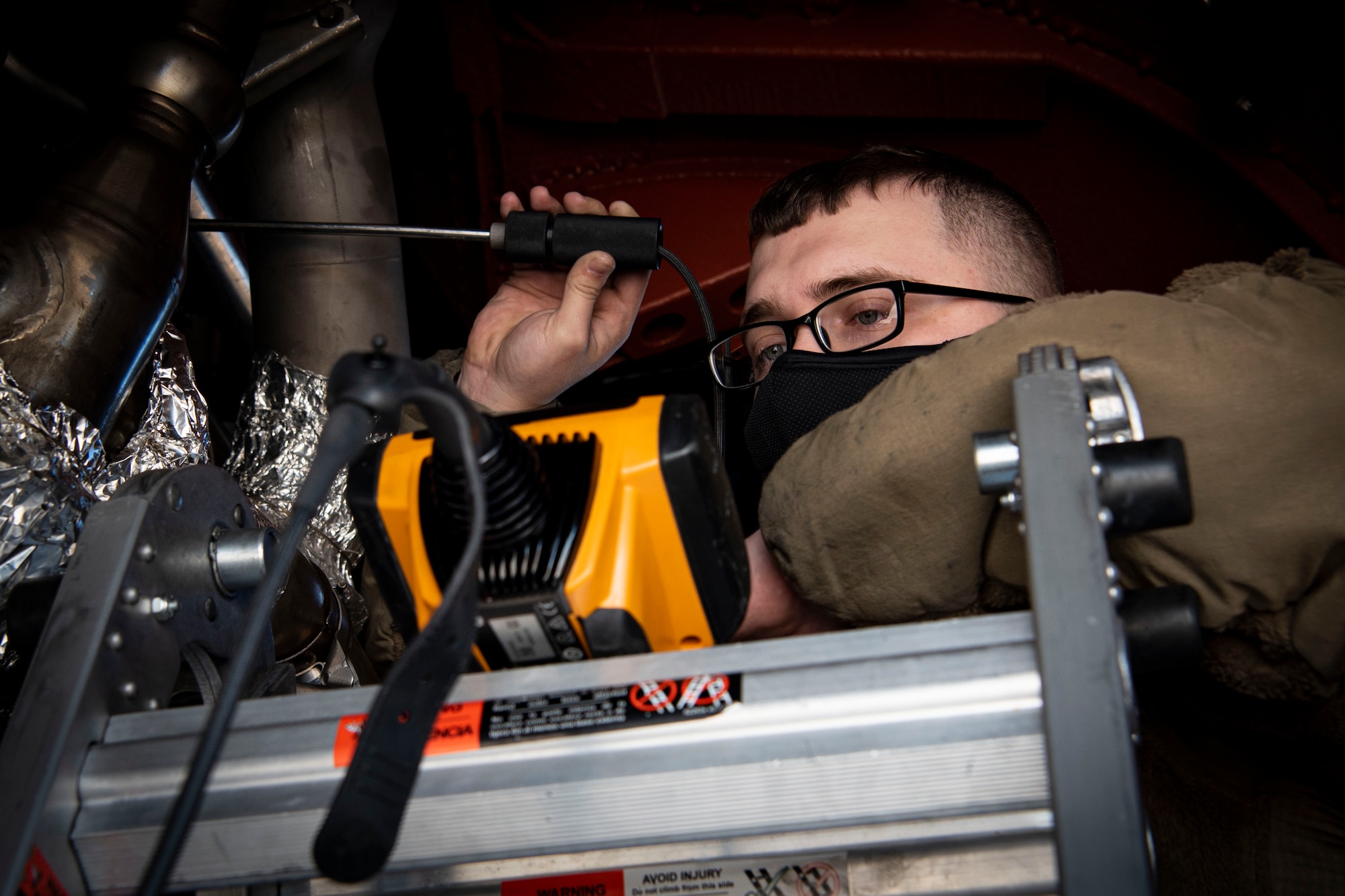 Photo of an Airman performing a borescope inspection on a KC-10 Extender compressor section.