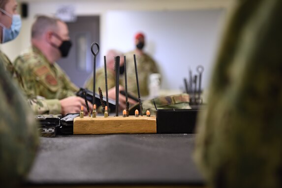 Firearm cleaning tools and dummy rounds on a table available to use during the Shooting in Excellence competition at the firing range, on Goodfellow Air Force Base, Texas, March 30, 2021. The provided supplies were used to prevent misfires, test optimum firing performance, and promote gun safety. (U.S. Air Force photo by Senior Airman Abbey Rieves)