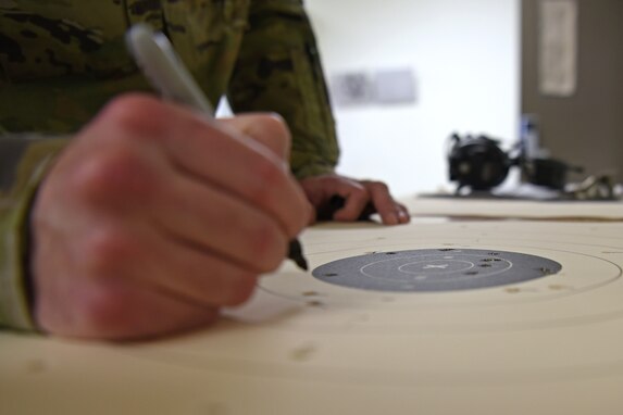 U.S. Air Force Senior Airman Sean Gardner, 17th Security Forces Squadron combat arms instructor, scores a target during the Shooting in Excellence competition at the firing range, on Goodfellow Air Force Base, Texas, March 30, 2021. Shots within the seven-point line and inward counted towards winning the competition. (U.S. Air Force Senior photo by Airman Abbey Rieves)