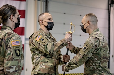 Col. Tim Brower (center), commander of 38th Troop Command, Alaska Army National Guard, passes the ceremonial scepter to Command Sgt. Maj. John Phlegar (right) during a change of responsibility ceremony on Joint Base Elmendorf-Richardson, Alaska, March 30. Phlegar assumed the role as the senior enlisted leader from Command Sgt. Maj. Maureen Meehan (left), making Phlegar the senior noncommissioned officer in charge of the brigade. (U.S. Army National Guard photo by Edward Eagerton)