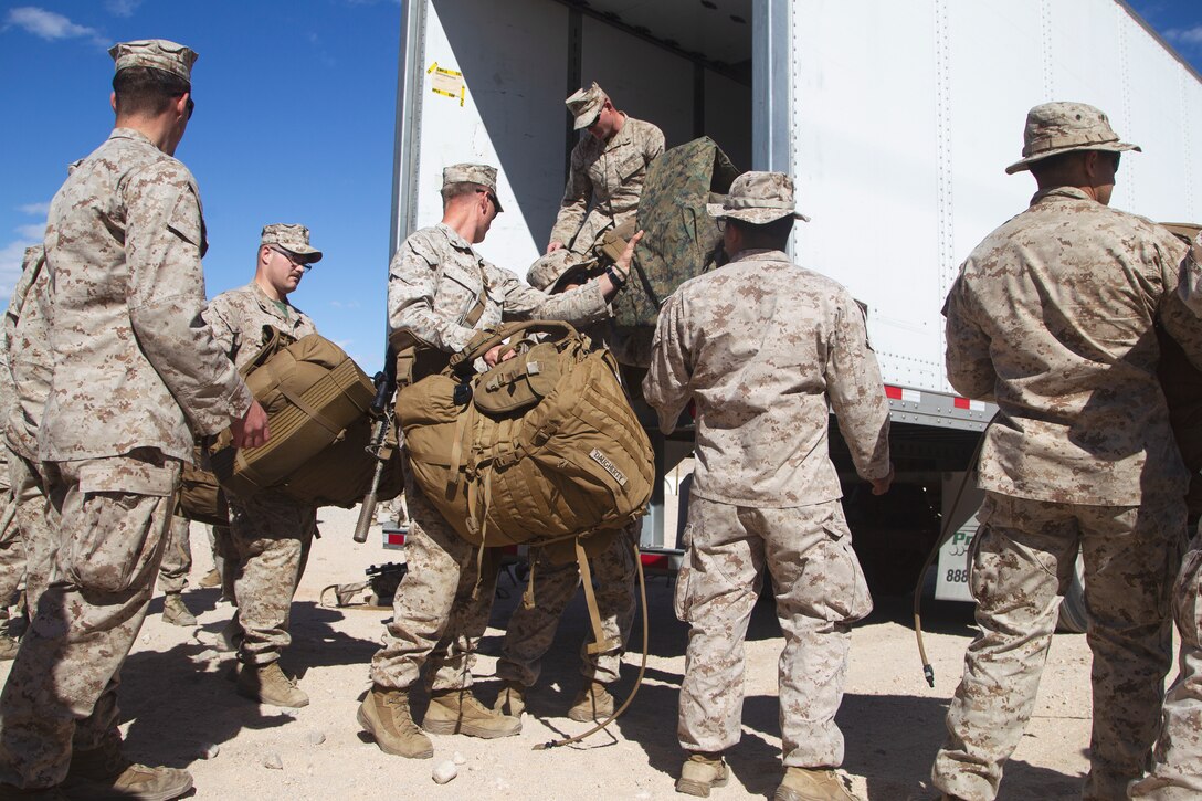 U.S. Marines with 1st Battalion, 5th Marine Regiment, 1st Marine Division, unload baggage after arriving aboard Marine Corps Air Ground Combat Center, Twentynine Palms, California, on March 26, 2021. Marines with 1/5 were transported from Camp Pendleton, California, to MCAGCC in order to take part in Marine Air Ground Task Force, Service Level Training Exercise 3-21. (U.S Marine Corps photo by Lance Cpl. Jaquliyn Davis)