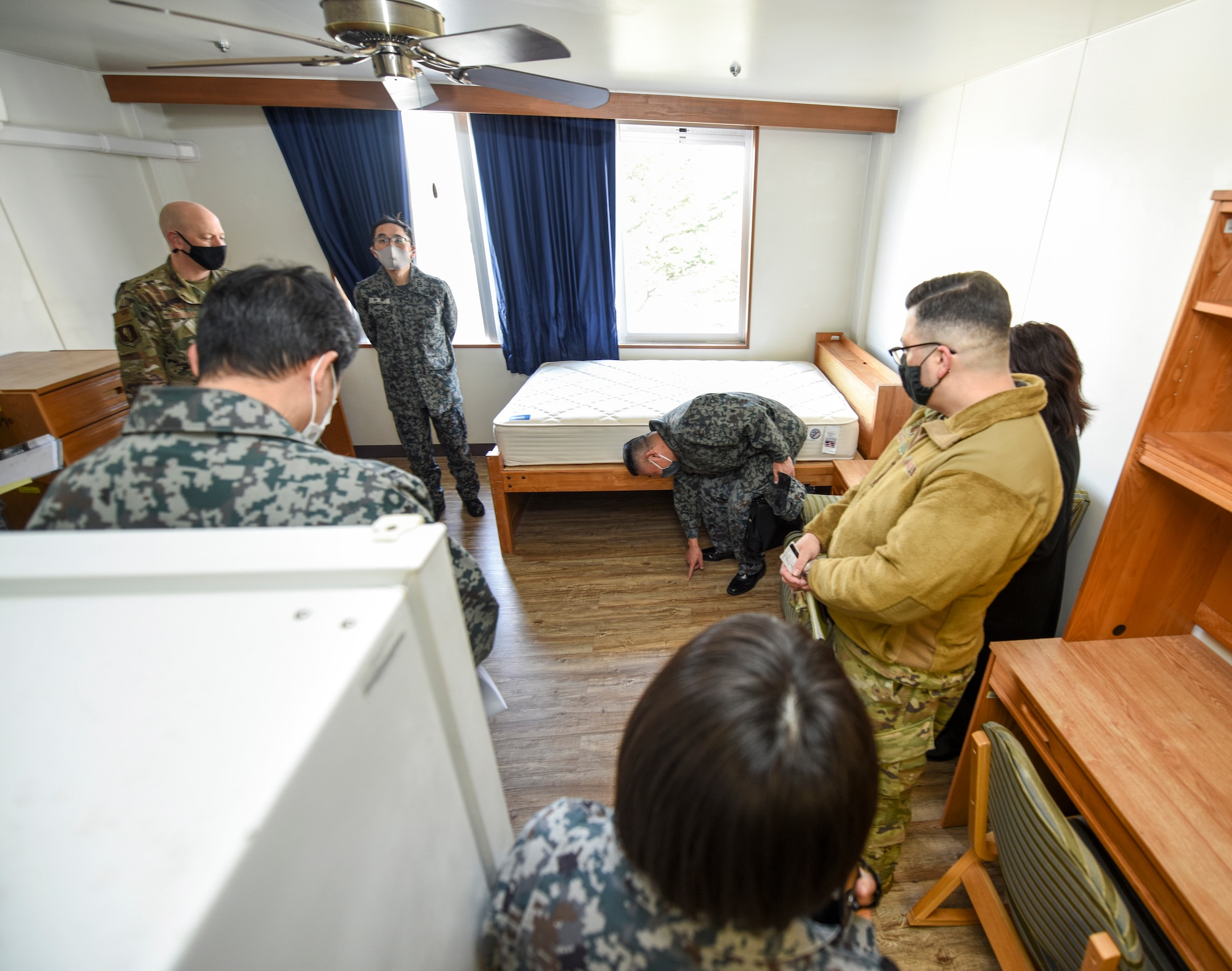 U.S. and Japanese Airmen stand in a dormitory room on the 35th Fighter Wing's Unaccompanied Housing campus at Misawa Air Base, Japan, Feb. 26, 2021. As they are in the process of improving their own campus, Japan Air Self-Defense Force leaders from the 3rd Air Wing took the tour to gain some perspective on how the 35th FW manages and operates its campus. During the tour, they got to ask questions about the furniture and appliance costs, determining the occupants of rooms, shared living spaces and even mold prevention. (U.S. Air Force photo by Tech. Sgt. Timothy Moore)