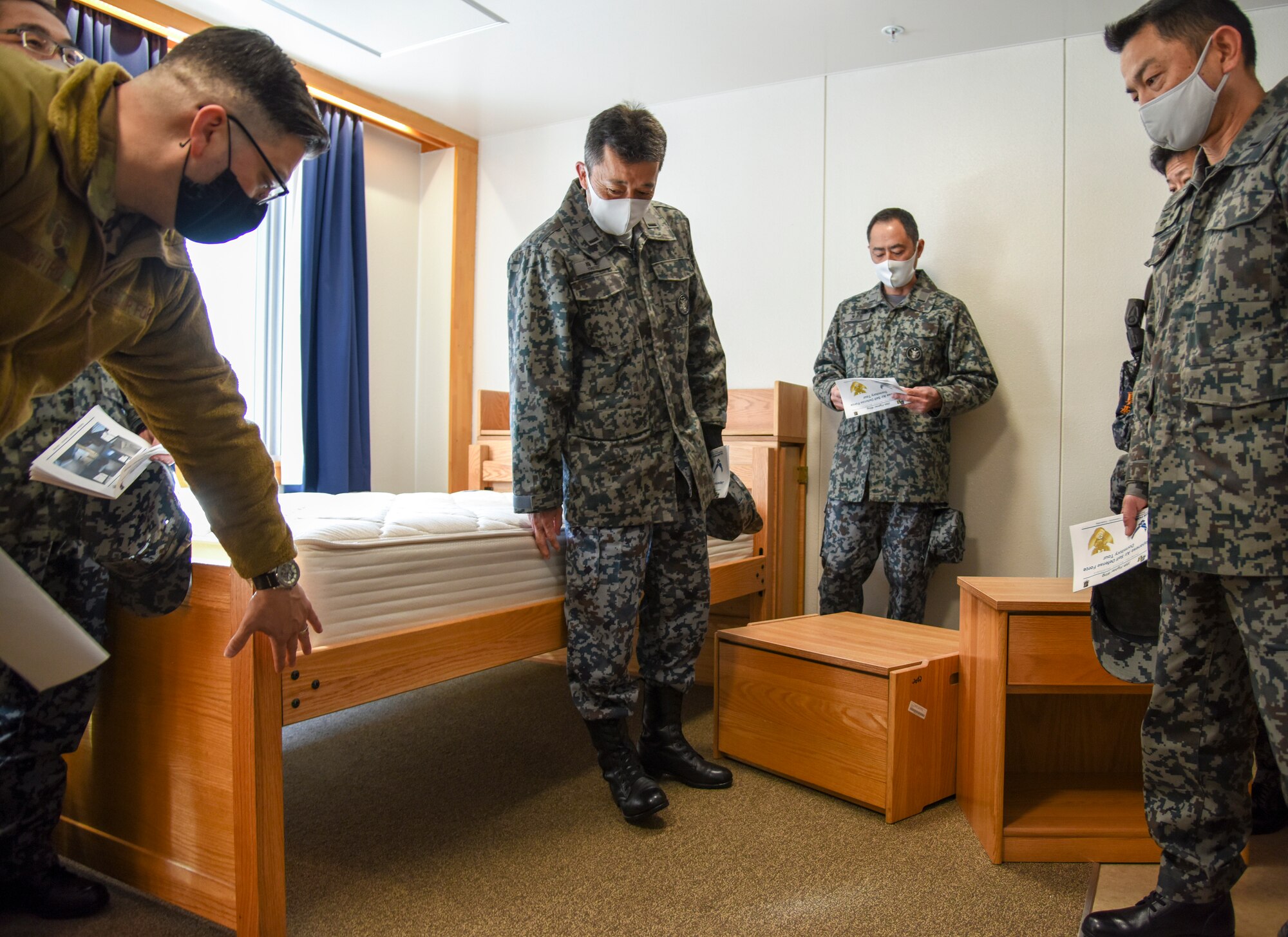 U.S. Air Force Master Sgt. William Castro, 35th Civil Engineer Squadron Unaccompanied Housing superintendent, explains the purpose of the furniture layout to Japan Air Self-Defense Force 3rd Air Wing leaders during a tour of the unaccompanied housing dormitory campus at Misawa Air Base, Japan, Feb. 26, 2021. As they are in the process of upgrading their unaccompanied housing living quarters, the JASDF leaders took the tour to gain some perspective on how the 35th Fighter Wing manages its dormitory campus. (U.S. Air Force photo by Tech. Sgt. Timothy Moore)