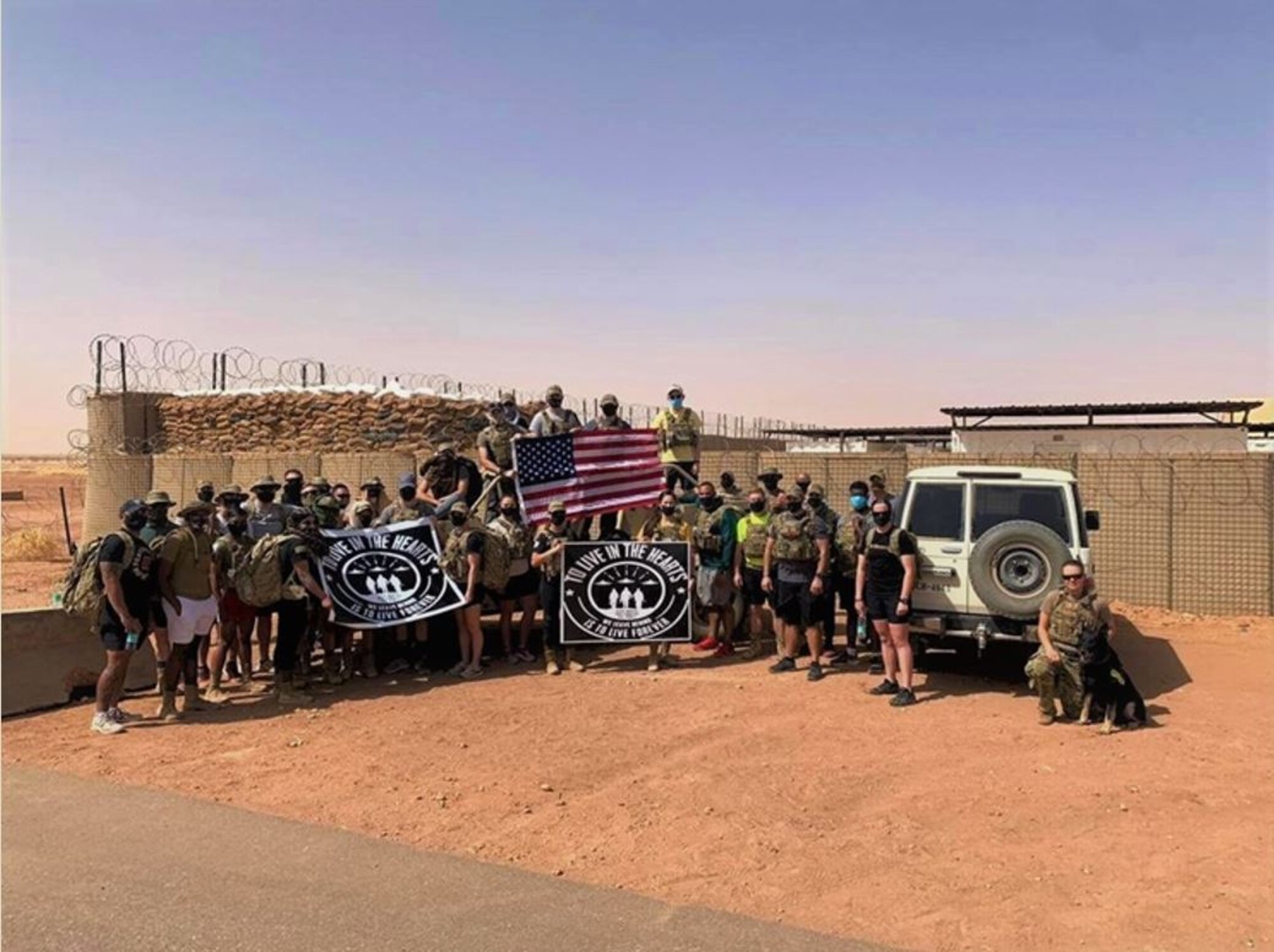 210422-F-XM048-1001 - Members of the 409th ESFS pose for a picture before the beginning of a memorial ruck on March 26, 2021 at Nigerien Air Base 201, Agadez, Niger. Day of the Defender was created to honor the lives  of three lost members from the 412th Security Forces Squadron at Edwards Air Force Base, California, in a three month time span. (Courtesy Photo)