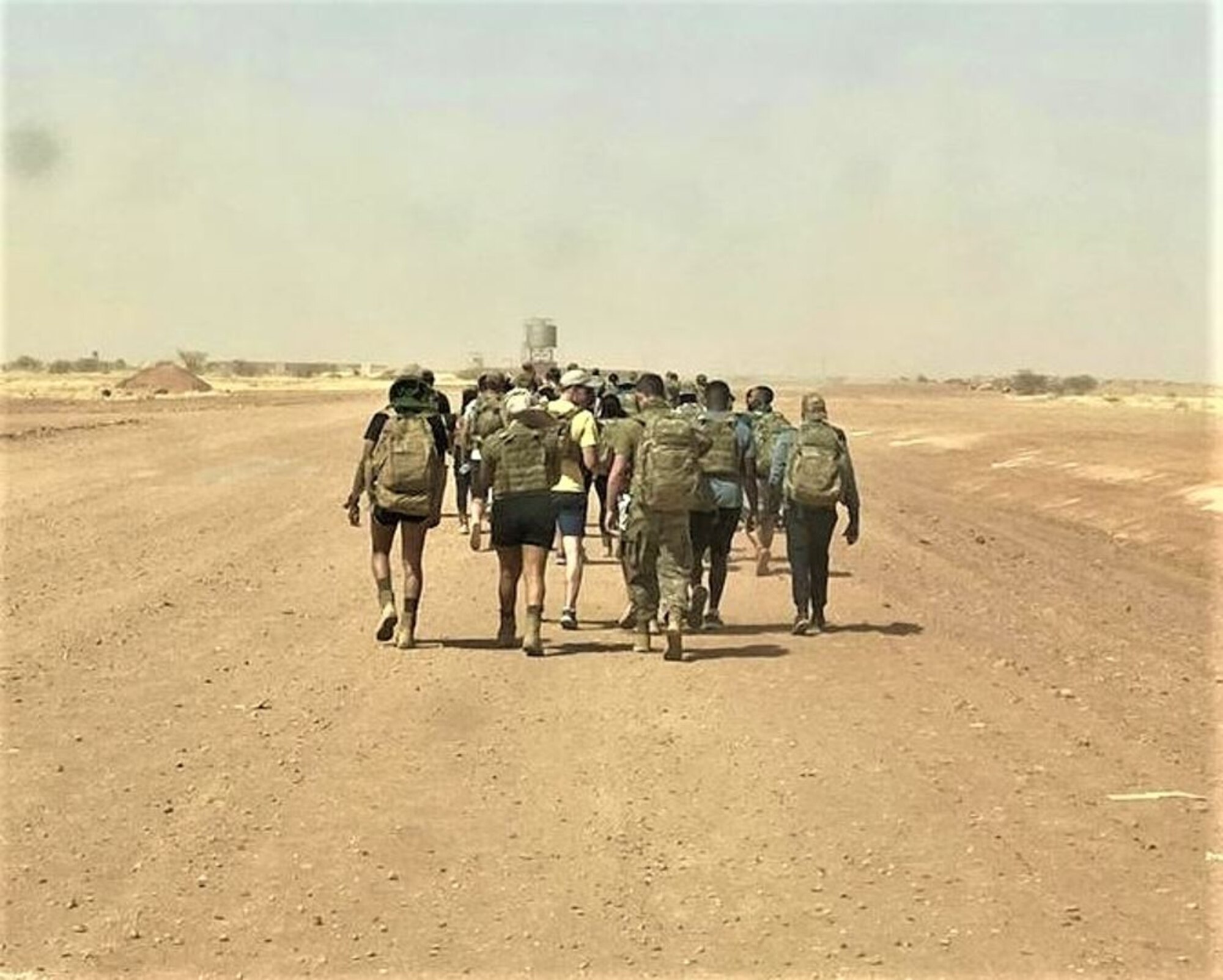 210422-F-XM048-1001 - Members of the 409th ESFS pose for a picture before the beginning of a memorial ruck on March 26, 2021 at Nigerien Air Base 201, Agadez, Niger. Day of the Defender was created to honor the lives  of three lost members from the 412th Security Forces Squadron at Edwards Air Force Base, California, in a three month time span. (Courtesy Photo)