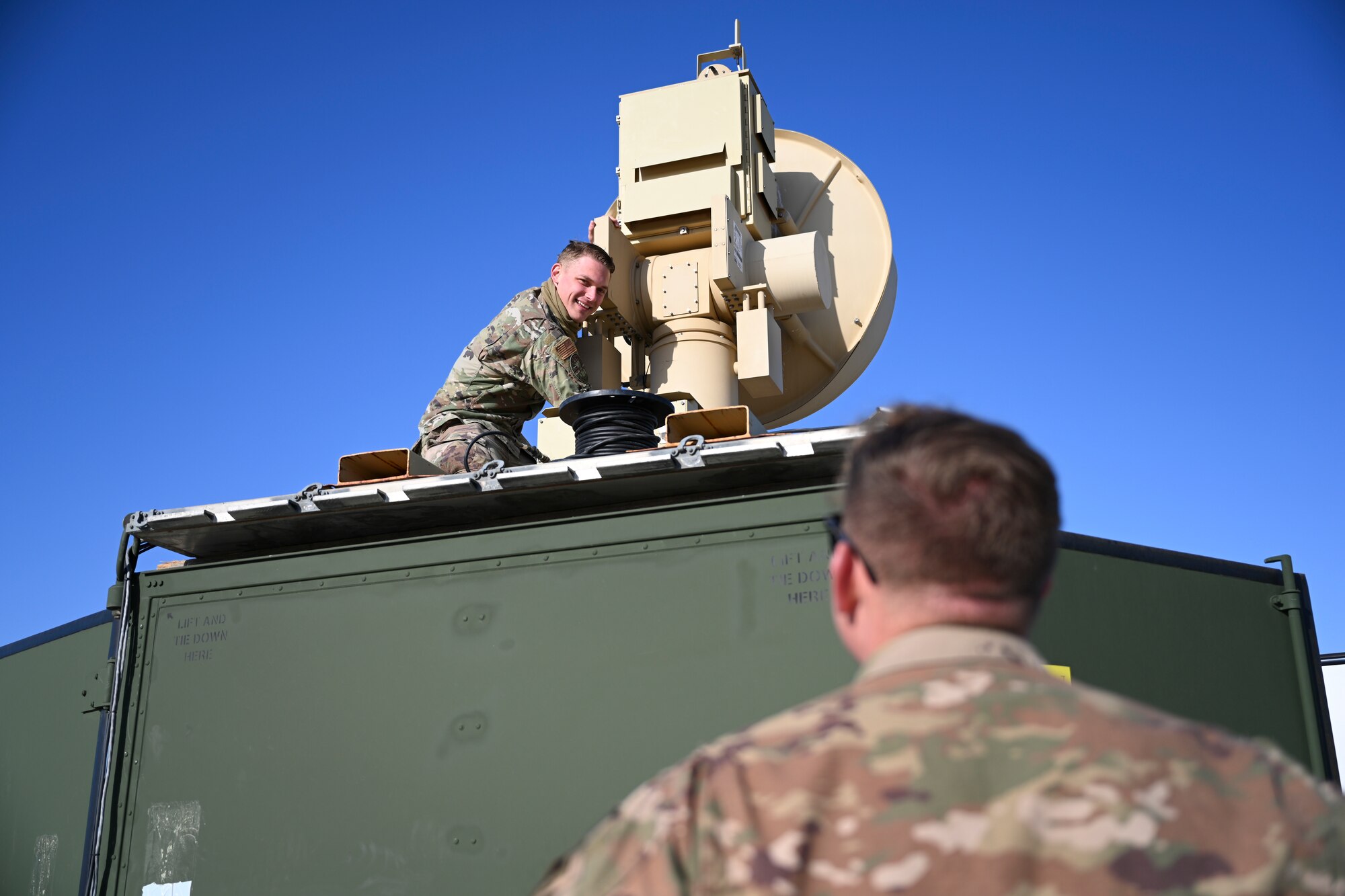 Senior Airman Colton Neal, 49th Aircraft Maintenance Squadron ground control station communications technician, routes and connects cables to the ground data terminal, April 16, 2021, on Naval Air Station Point Mugu, California. This piece of equipment provides a line-of-sight connection with MQ-9 Reapers for launch and recovery. (U.S. Air Force photo by Senior Airman Kristin Weathersby)