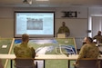 U.S. Army Col. Scott Meyers, commander, Camp Grayling Joint Maneuver Training Center, Michigan Army National Guard, briefs U.S. Army Gen. Daniel Hokanson, chief, National Guard Bureau (left) and U.S. Army Maj. Gen. Paul Rogers, adjutant general and director of the Department of Military and Veteran Affairs, on the National All-Domain Warfighting Center’s capabilities at Camp Grayling Joint Maneuver Training Center in Grayling, Michigan on April 13, 2021.