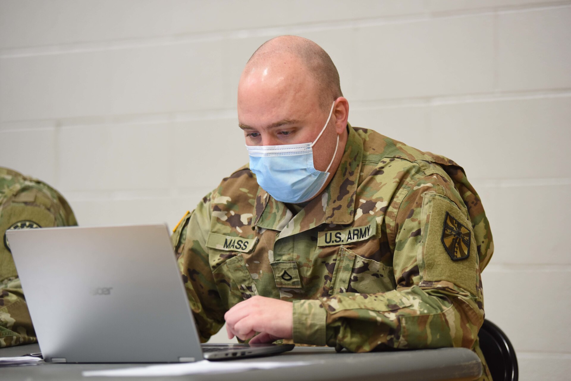 U.S. Army Pfc. Donald Mass, a shower and laundry specialist with the 464th Quartermaster Company, Michigan Army National Guard, currently serving with Task Force Spartan, a Michigan COVID-19 Vaccination Testing Team (CVTT), provides administrative assistance during a recent community-based vaccination event in White Pigeon, Michigan on April 22, 2021.