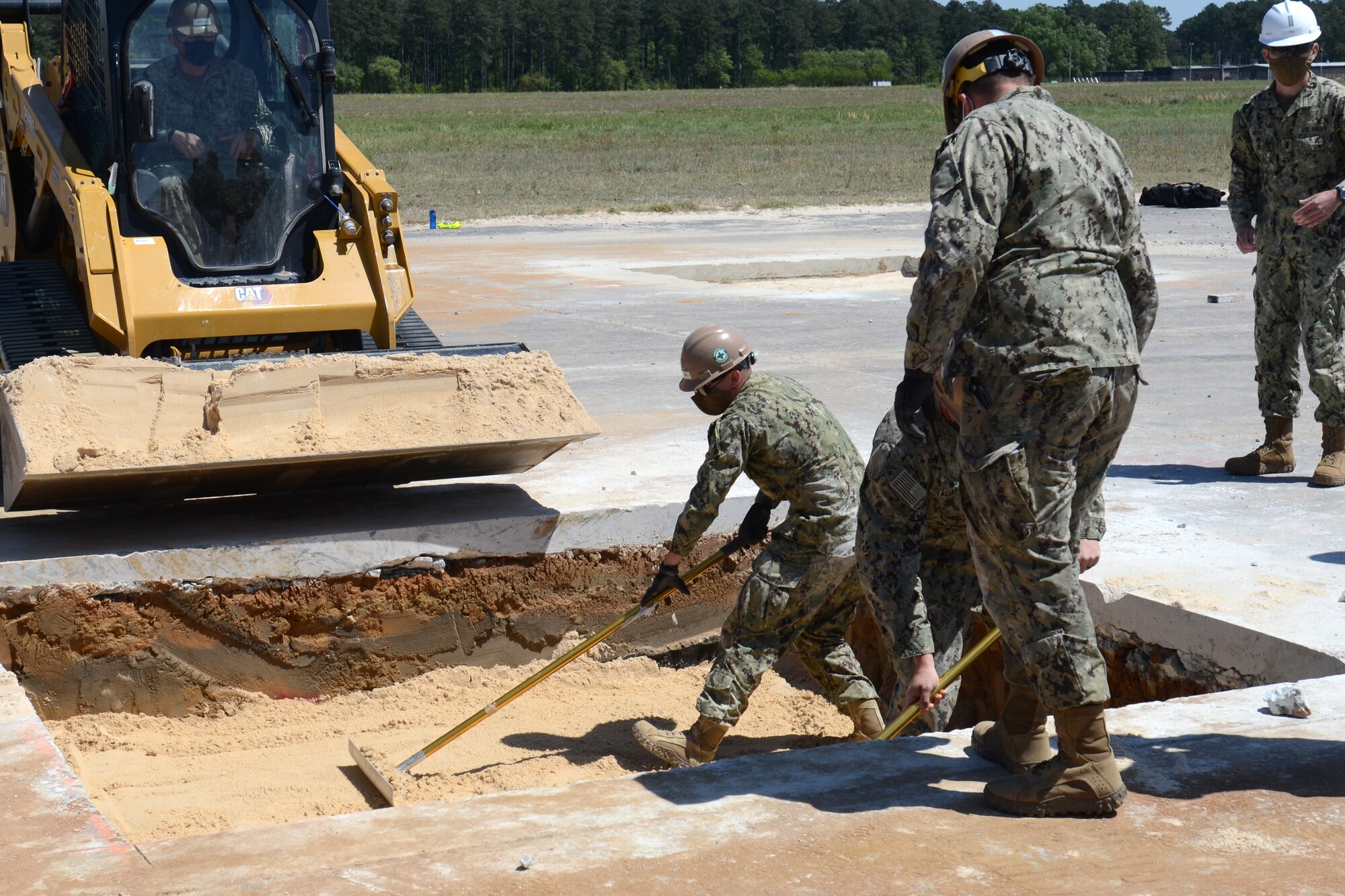 U.S. Navy engineers from Navy Mobile Construction Battalion 133, Gulfport, Mississippi, fill in an excavated hole during an Expedient and Expeditionary Airfield Damage Repair (E-ADR) Joint Capability Technology Demonstration at McEntire Joint National Guard Base, South Carolina, April 22, 2021. The demonstration field tests the “just enough, just-in-time” repair capability on a decommissioned runway at McEntire Joint National Guard Base. The Department of Defense’s E-ADR concept uses local materials and minimal personnel and equipment in order to expedite a temporary runway repair. (U.S. Air National Guard photo by Lt. Col. Jim St.Clair, 169th Fighter Wing Public Affairs)