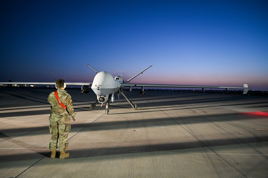 Senior Airman Laura Riggs, 49th Aircraft Maintenance Squadron assistant dedicated crew chief, marshals a MQ-9 Reaper to park during Exercise Agile Reaper, April 16, 2021, on Point Mugu Naval Air Station, California. Throughout the exercise, Airmen worked different shifts to execute 24-hour operations to test the MQ-9’s readiness capabilities in both day and night conditions.  (U.S. Air Force photo by Senior Airman Kristin Weathersby)