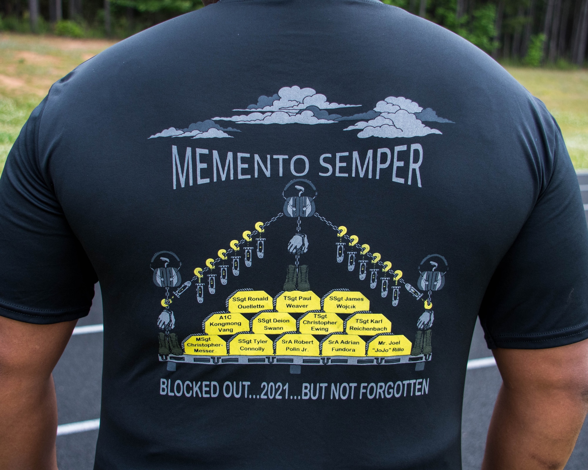 Master Sgt. Ronald Murphy II showcases his shirt that commemorates the 12 fallen team members with the slogan “Memento Semper,” which translates to “Remember Always.” Airmen from Dobbins came together for a Port Dawgs Memorial Run that was held at the base track on May 2. (U.S. Air Force photo/Staff Sgt. Josh Kincaid)