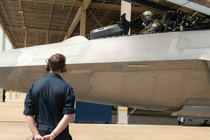 An F-22 crew chief watches on as the pilot prepares to take flight in the aircraft.