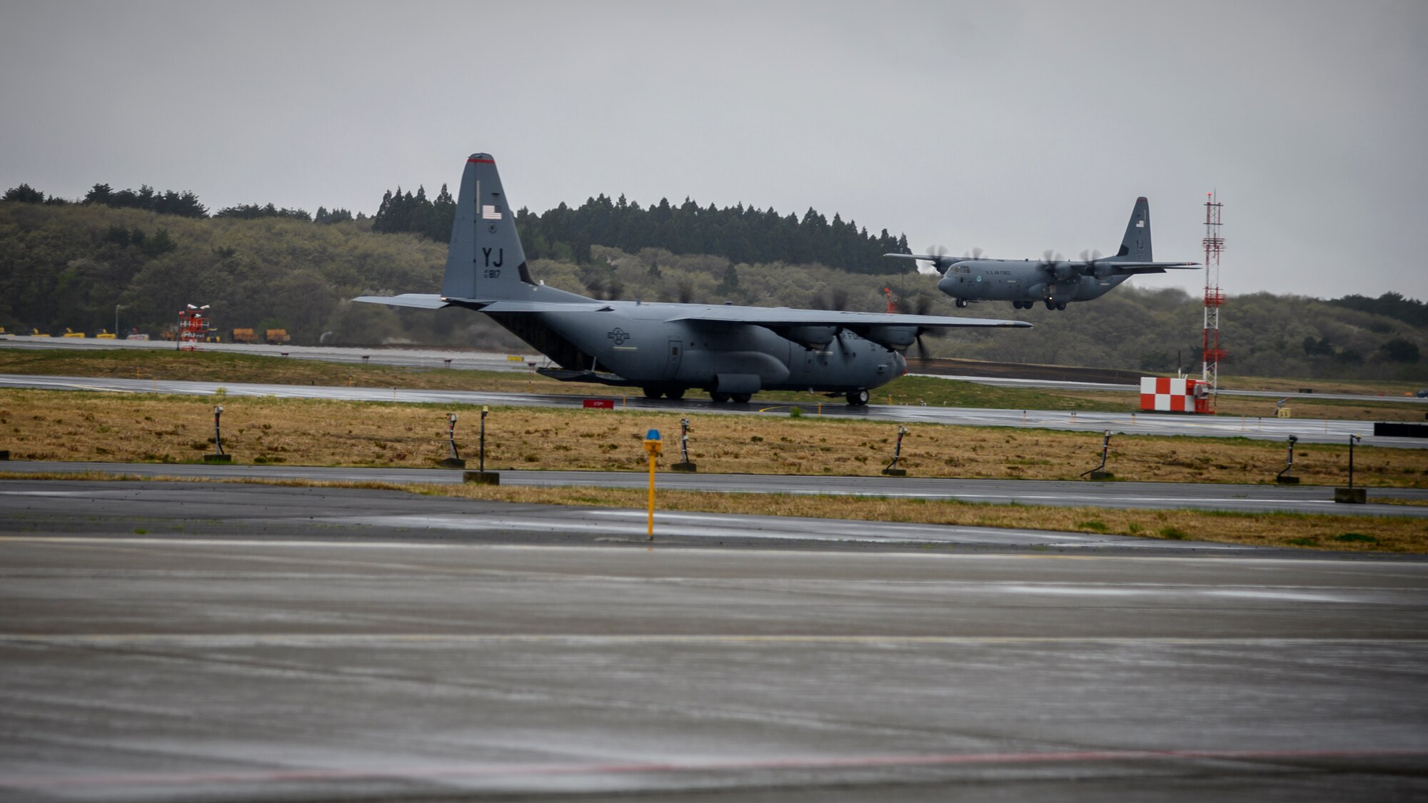 A C-130J Super Hercules from the 374th Airlift Wing lands while the other C-130 taxis down the runway during the Beverly Sunrise 21-05 Readiness Exercise at Misawa Air Base, Japan, May 2, 2021. The C-130s are transporting cargo and personnel to support the 35th Fighter Wing’s Agile Combat Employment capabilities. (U.S. Air Force photo by Airman 1st Class China M. Shock)